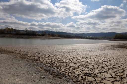 The cracks in the dry soil next to a drained pond