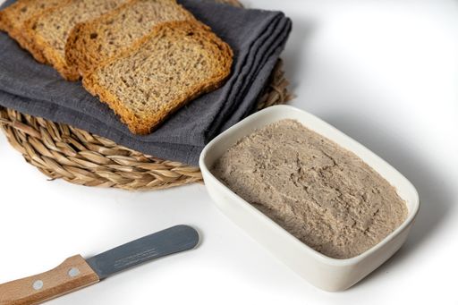 A closeup of the delicious vegan mushroom and walnut pate in the plate with slices of bread