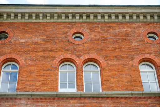 A low angle shot of a classic style building top floor with rounded windows