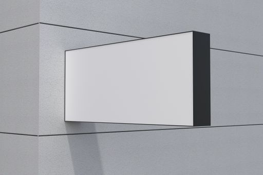 A closeup view of a blank rectangular shaped billboard with a white space attached to the wall