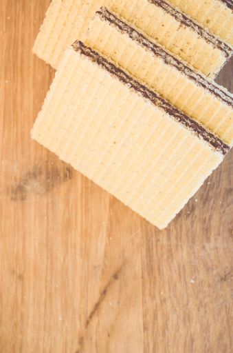 A top view of delicious crispy chocolate wafers on a wooden table