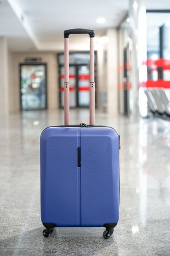 A vertical shot of blue luggage in the middle of the station