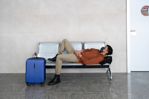 A closeup of a person in a facial mask at the airport waiting for his flight - a new normal concept