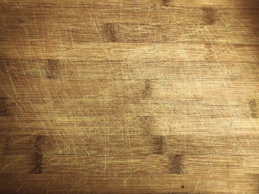 A closeup of a wooden surface with scratches on it under the lights