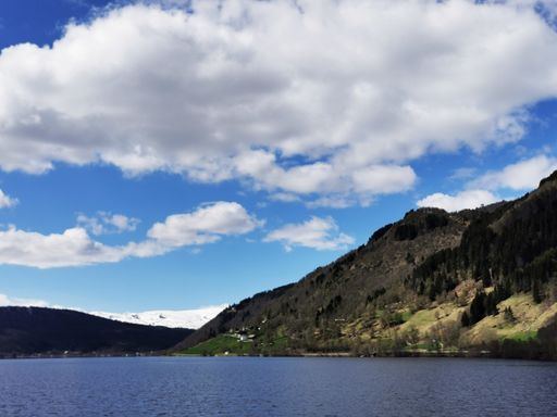 A scenic shot of the Oppheimsvatnet lake in Norway surrounded by mountains on a cloudy weather