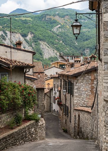 A picturesque alleyway with stunning mountainous landscape in the background in the Emilia-Romagna region, Italy