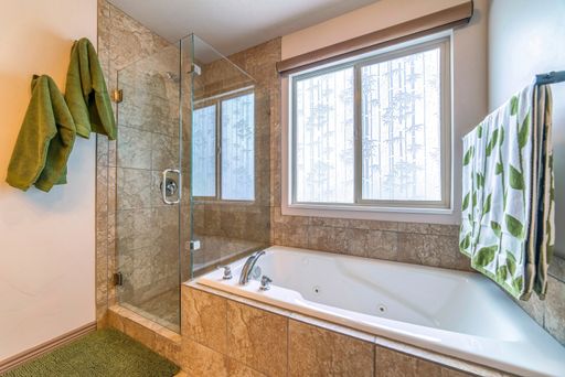 A minimalistic bathroom interior design in white and brown colors and with green towels