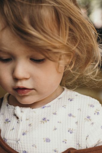 An adorable blonde young Caucasian girl looking at something