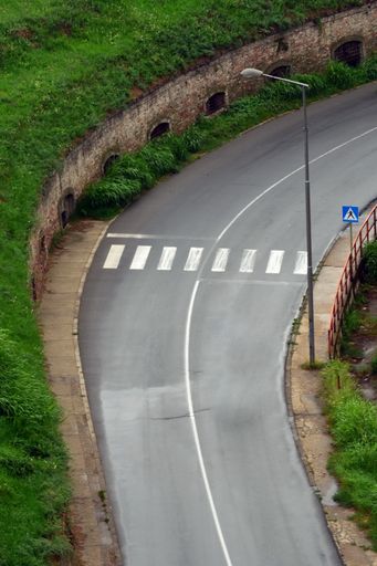 A close-up shot of curvy road with a pedestrian crossing