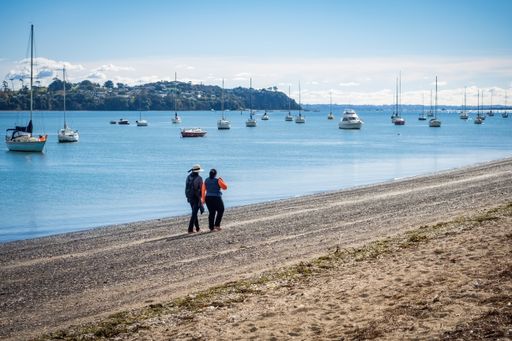 Two women walking along Bucklands beach. Auckland, New Zealand - May 13, 2021