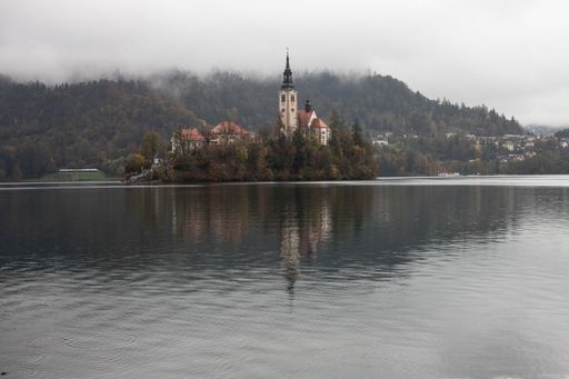 A scenic lakeside landscape featuring a small island in the middle of Lake Bled in Slovenia.