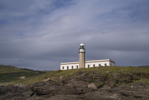 The Corrubedo lighthouse, Galicia, Spain surrounded by the huge rocks and fields