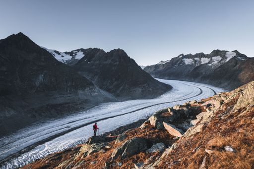 A scenic view of a hiker at sunset on the Aletsch glacier in Wallis, Switzerland