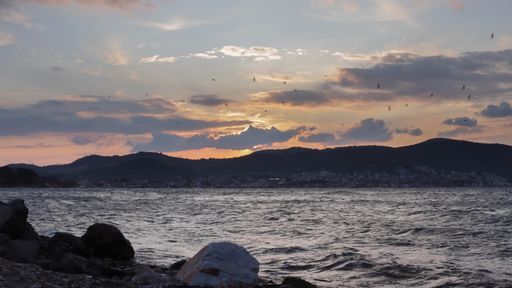A beautiful sunset scenery over the lake with silhouettes of hills in the background
