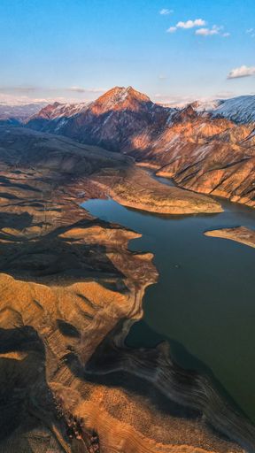 Vertical view of a beautiful landscape, mountain and a lake during the sunset. Mountain and a lake during the golden hour.