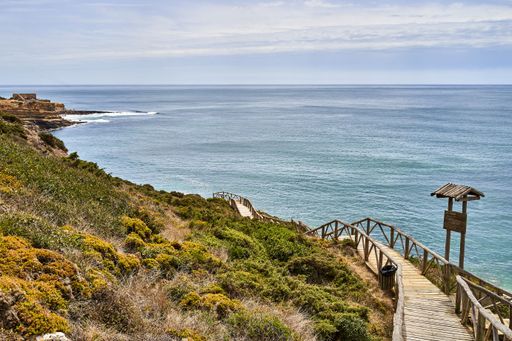 A beach staircase leading to the shoreline on the Atlantic coast in Ericeira, Portugal