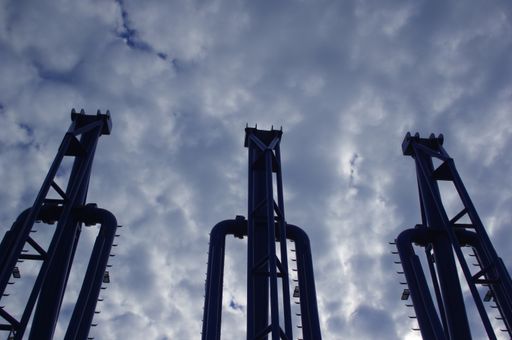 A low angle shot of an industrial plant with high pipes on a cloudy day