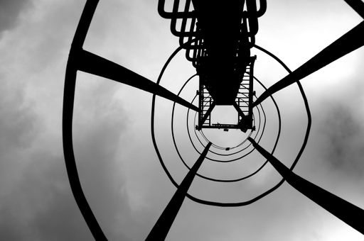 A low angle shot of a high industrial tower on background of the sky