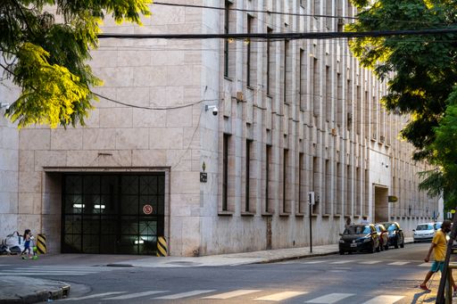 Photo of the corner of the Provincial Court of Rosario city with tree leaves on the sides and very few people walking due to the pandemic