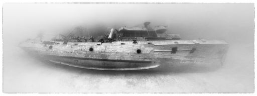 An old framed photograph of the famous USS Kittiwake shipwreck in Cayman islands