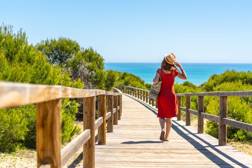 A young girl on the wooden path to Playa Moncayo in Guardamar del Segura next to Torrevieja, Alicante. Community of Valencia. Spain