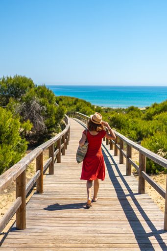 A young girl on the wooden path to Playa Moncayo in Guardamar del Segura next to Torrevieja, Alicante. Community of Valencia. Spain