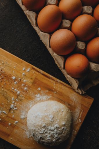 A vertical shot of homemade dough and eggs on a table
