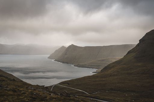 Breathtaking aerial view of a mountain peak at sunset, with an expansive ocean in the foreground