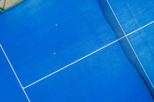 overhead aerial view with a drone of a blue paddle tennis court
