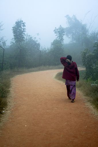 A back view of a girl in red sweater taking stroll in early morning
