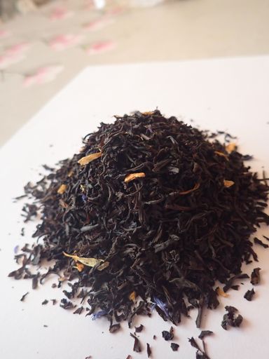 A vertical shot of dry black tea on a white surface