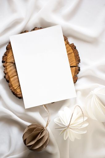 A white paper sheet is securely attached to a wooden surface, with several decorative items scattered around it