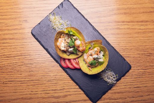 A top view shot of two unrolled tacos, a Mexican food on a wooden surface