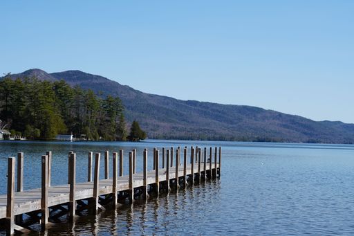 A scenic view of a pier on a tranquil lake on a sunny day