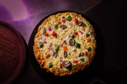 A top view of a delicious pizza with mushrooms, melted cheese, and vegetables on the table