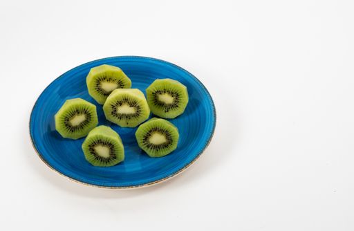 A closeup shot of green kiwis served on a blue plate