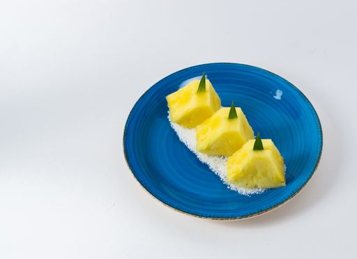 A closeup shot of pineapple slices served on a blue plate