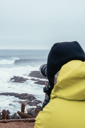 surf photographer, giant waves, extreme sports, punta de lobos, Pichilemu, Chile. cloudy day