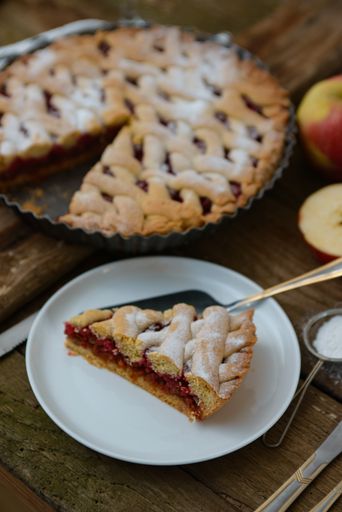 A vertical shot of a piece of homemade apple pie on a white plate