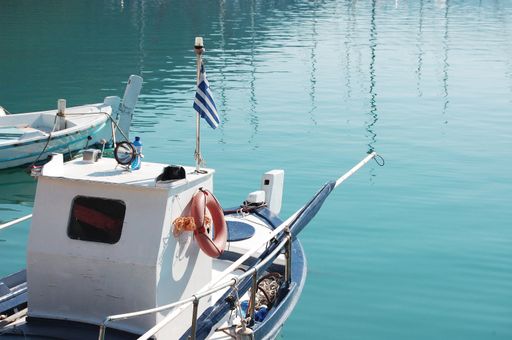 A closeup of a boat resting on the water on a sunny day at Greek islands