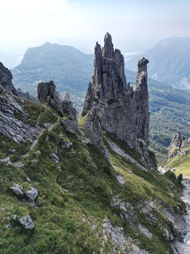 A majestic rocky mountain peak towers above a tranquil river winding through a lush valley below