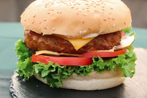 An appetizing hamburger, served on a plate, ready to be consumed.