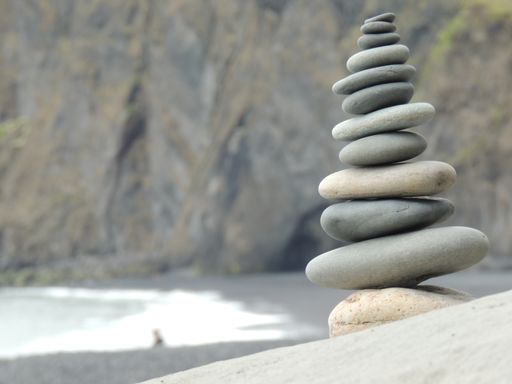 A vertical of gray stones stacked on top of each other on the beach on the coast