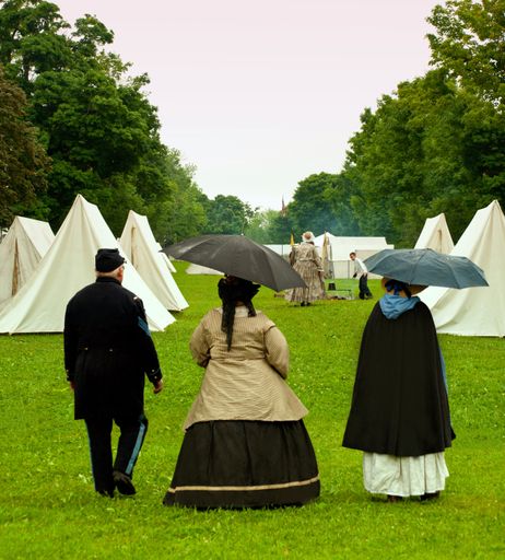 actors walking through a civil war reenactment camp