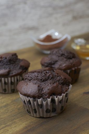 A vertical shot of delicious chocolate muffins on a wooden table
