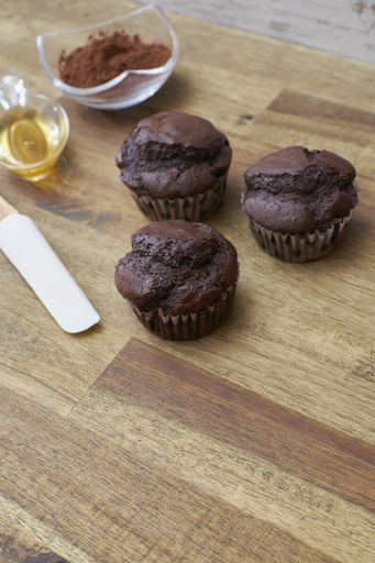 A high angle shot of delicious chocolate muffins on a wooden table