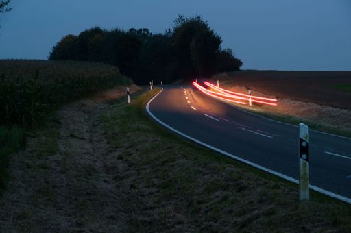 A long exposure shot of car lights illuminating the street during the nighttime