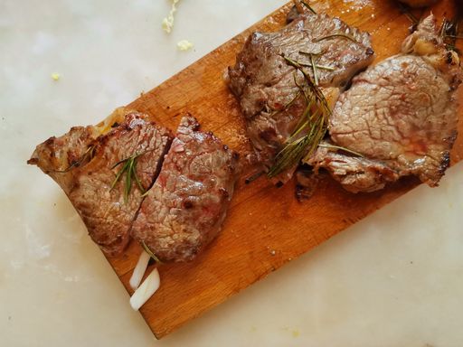 A top view of appetizing fried beef fillets on a wooden board