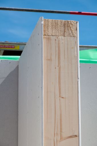 A white building wall with a wooden plank. Civil Engineering
