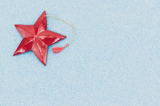A high angle shot of a star-shaped Christmas tree decoration on a blue surface